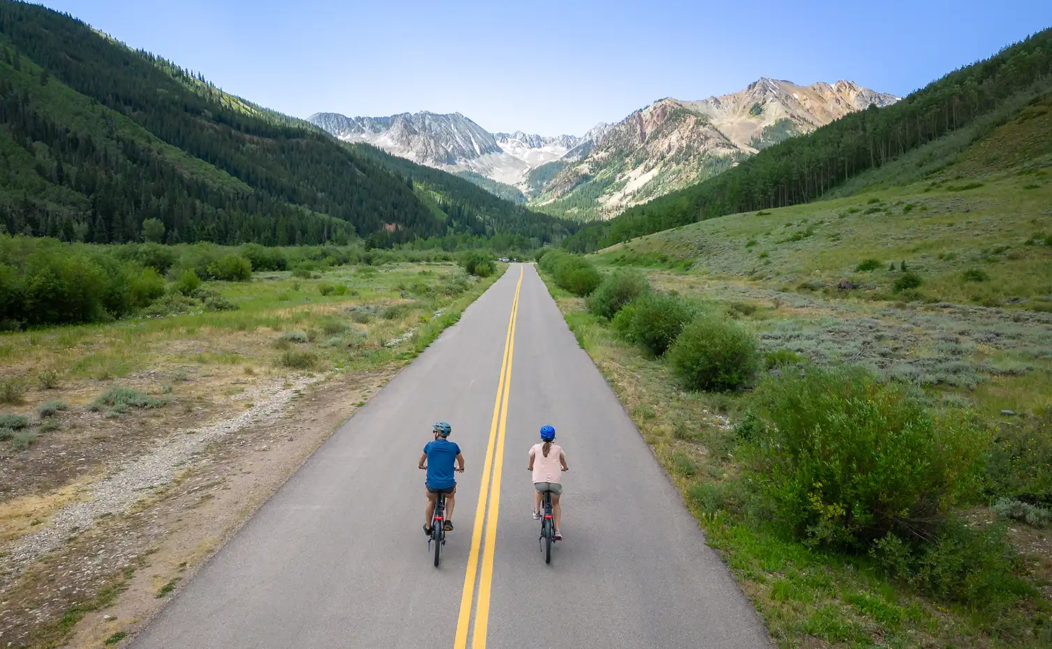A couple e-bikes down a mountain road near Aspen, Colorado.